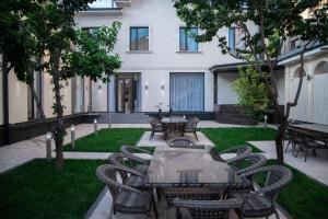 a patio with a table and chairs in front of a building at Turon Lux Hotel in Samarkand