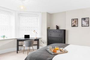 a bedroom with a bed with a desk and a chair at Stunning 2 bedroom apartment in fantastic location in Bristol