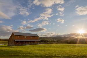 a barn in a field with the sun in the sky at The Barracks, Tocal in Paterson