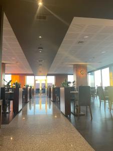 a dining room with tables and chairs in a building at Hotel Versatile in Guarda