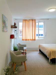 1 dormitorio con 1 cama, 1 silla y 1 ventana en DUNKE, en Dunkerque