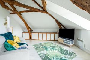 uma sala de estar com um sofá e uma televisão de ecrã plano em Le Marché Cosy à Vernon-Giverny - Claude Monet - Downtown em Vernon