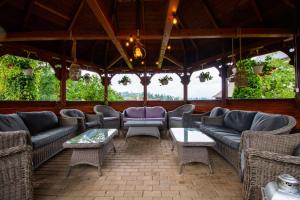 a screened in porch with couches and tables at Tatrzański Gościniec in Leśnica