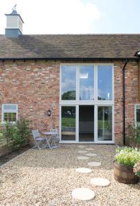 Casa de ladrillo con patio y banco en The Silver Birch Cottage - Greentrees Estate, en Haywards Heath