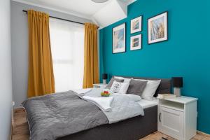 a blue bedroom with a bed with a blue wall at Little Laguna Apartments Sauna & Parking by Noclegi Renters in Międzywodzie +89 photos