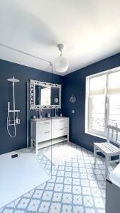 ヴィレ・シュル・メールにあるVilla Renéの青い壁のバスルーム(ガラス張りのシャワー付)