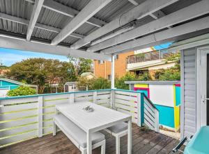 a white table on the deck of a house at Coastal Vibes - Walk to beach, Marina, Cafes and Pubs in Shellharbour