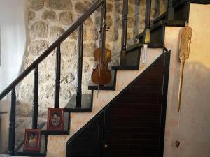 a staircase with a violin and pictures on the wall at Seaside dream in Trstenik +4 photos