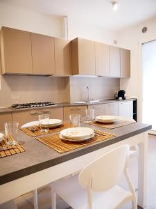 a kitchen with a table with plates and glasses on it at Ristoro 5 - Splendido 100 mq, nuovo e luminoso in Preganziol