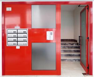 - une porte rouge dans un bâtiment avec des escaliers dans l'établissement Ristoro 5 - Splendido 100 mq, nuovo e luminoso, à Preganziol