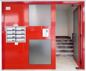 a red door in a building with stairs at Ristoro 5 - Splendido 100 mq, nuovo e luminoso in Preganziol