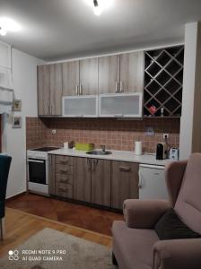 uma cozinha com armários de madeira e um sofá num quarto em Mio Lux em Baošići