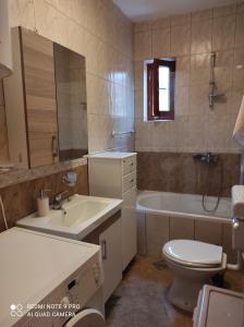 uma casa de banho com um lavatório, um WC e uma banheira em Mio Lux em Baošići
