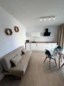 ein Wohnzimmer mit einem Sofa und einem Glastisch in der Unterkunft Apartamentos Buganvilla Roquetas de Mar in Roquetas de Mar