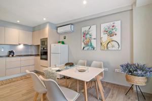 cocina y comedor con mesa blanca y sillas en Casa Rebelo da Silva, en Faro