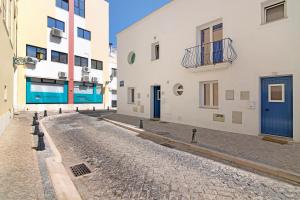 a cobblestone street in a city with buildings at Casa Rebelo da Silva in Faro