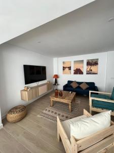 ein Wohnzimmer mit einem blauen Sofa und einem TV in der Unterkunft Apartamentos Buganvilla Roquetas de Mar in Roquetas de Mar