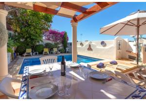- une table avec des verres et un parasol à côté de la piscine dans l'établissement Casa Monsoria, à Carvoeiro