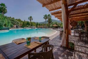 eine Terrasse mit Tisch und Stühlen neben einem Swimmingpool in der Unterkunft Il Monastero in Geremèas