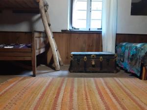 um quarto com uma cama e uma bagageira sentada no chão em Albergue ESCANLAR em Lugo