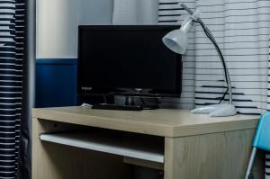 a desk with a computer monitor and a lamp on it at Pensión Blanca B&B in León