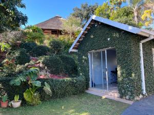 a house with a glass door in a garden at Acoustic Guest House in Pretoria