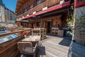 a restaurant with tables and chairs on a deck at Hotel le Sherpa in Les Deux Alpes