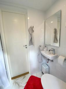 a white bathroom with a sink and a mirror at Maasikmäe- unustamatu puhkus looduse vaikuses in Tagaküla