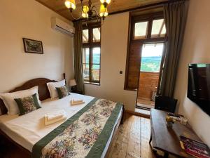 a bedroom with a bed and a tv and a window at Tsarevets Residence in Veliko Tŭrnovo