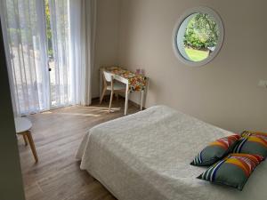 a bedroom with a bed and a table and a mirror at L’oliveraie in Robion en Luberon