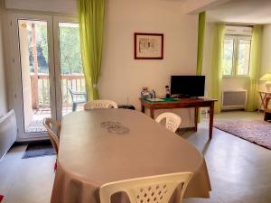 comedor con mesa y escritorio con ordenador en Appartement 20, avec balcon, Résidence de l'Ars en Aulus-les-Bains