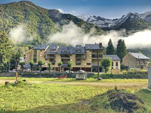 un gran edificio frente a una montaña en Appartement 20, avec balcon, Résidence de l'Ars en Aulus-les-Bains