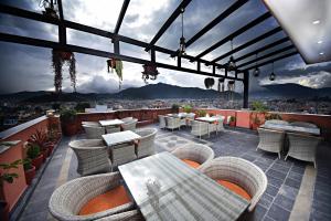 a patio with wicker chairs and tables on a roof at Everest Boutique Hotel in Kathmandu