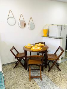 a kitchen with a table and chairs and a refrigerator at Flat vista incrível in Arraial do Cabo +38 photos