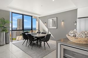 a dining room with a table and chairs and a fireplace at Aria Apartments in Gold Coast