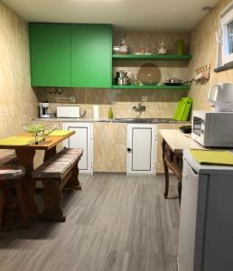 cocina con armarios verdes y mesa de madera en Casa Oliveiras - Casas do Sinhel, en Alvares
