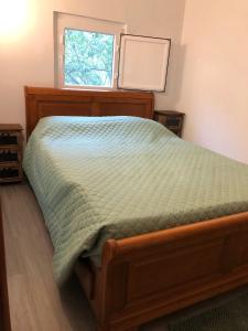 a bedroom with a bed with a green comforter and a window at Casa Oliveiras - Casas do Sinhel in Alvares
