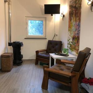 a living room with a chair and a table and a window at Casa Oliveiras - Casas do Sinhel in Alvares
