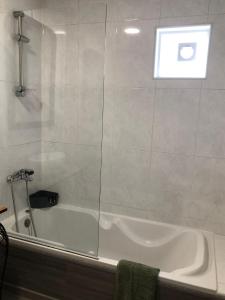 a bathroom with a bath tub with a window at Casa Oliveiras - Casas do Sinhel in Alvares +15 photos