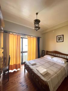 sypialnia z dużym łóżkiem i oknem w obiekcie Abrigo do Portinho w mieście Vila Praia de Âncora