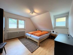 1 dormitorio con 1 cama con almohadas de color naranja en Ferienwohnung Kinzigblick *NEU* für Familien im Schwarzwald Kinzigtal, en Schenkenzell