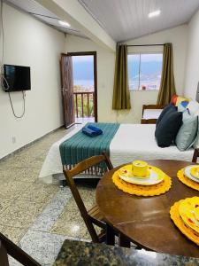 a room with a bed and a table with a tableablish at Flat vista incrível in Arraial do Cabo