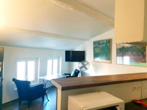 a room with a desk and a table and chairs at Appartement à L'Isle-sur-la-Sorgue avec vue sur la ville in LʼIsle-sur-la-Sorgue