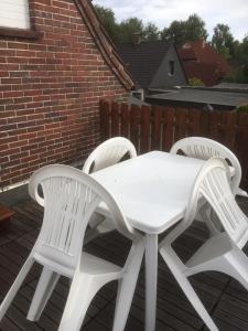 2 chaises blanches et une table blanche sur une terrasse dans l'établissement Ferienwohnung Bruni I, à Oldenbourg