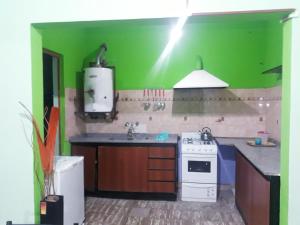 uma cozinha verde com um fogão e um lavatório em Urquiza61 em Capilla del Monte