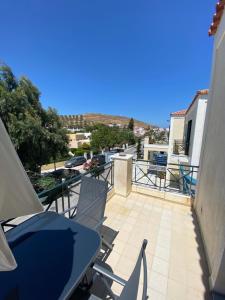 eine Terrasse mit einem Tisch und Stühlen auf dem Balkon in der Unterkunft Anoixi Apartments in Korissia