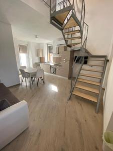 a living room with a staircase and a dining room at Around Lago Maggiore apartments in Reno Di Leggiuno