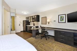Candlewood Suites Huntersville-Lake Norman Area, an IHG Hotel في هانترسفيل: غرفة في الفندق مع سرير ومكتب