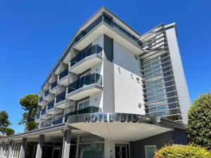 un edificio bianco con un cartello hotel sopra di Hotel Lily a Bibione