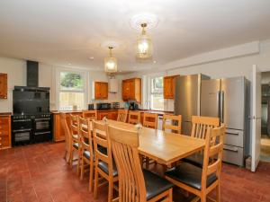 Il comprend une cuisine équipée d'une table en bois et d'un réfrigérateur. dans l'établissement White Roses, à Ross-on-Wye